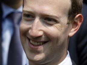 FILE - In this May 23, 2018 file phpoto, Facebook's CEO Mark Zuckerberg smiles during a picture with guests attending the "Tech for Good" Summit at the Elysee Palace in Paris. Zuckerberg's latest attempt to explain Facebook's data-sharing practices is notable for its omissions as well as what it plays up and plays down. In a Wall Street Journal op-ed Thursday, Jan. 24, 2019, titled "The Facts About Facebook," the CEO doubles down on previous talking points while leaving out, for example, a Federal Trade Commission investigation over its privacy practices.