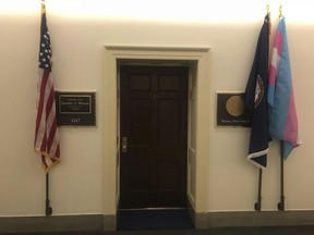 In this photo provided by the Office of Congresswoman Jennifer Wexton, a transgender pride flag, right, is displayed along with U.S. left, and Virginia, second from right, flags, outside newly elected Virginia congresswoman Rep. Jennifer Wexton's office in Washington on Friday, Jan. 4, 2019. Wexton is a Democrat from 10th District in northern Virginia who was sworn in Thursday, Jan. 3. (Office of Congresswoman Jennifer Wexton via AP)