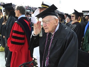 FILE - In this May 5, 2018, file photo, World War II veteran Bob Barger salutes during the national anthem at the commencement ceremony at the University of Toledo, in Toledo, Ohio. Barger, a World War II veteran from Ohio who received his college degree last spring nearly 70 years after he last sat in a classroom, died Wednesday, Jan. 9, 2019, Newcomer Funeral Home in Toledo said. He was 97.
