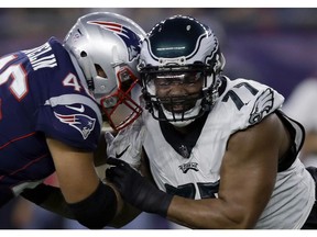FILE- In this Aug. 16, 2018, file photo, Philadelphia Eagles defensive end Michael Bennett (77) tries to move past a block from New England Patriots fullback James Develin (46) during the first half of a preseason NFL football game in Foxborough, Mass. Develin is one of the few remaining true fullbacks in the NFL whose primary job is to just put his pads down and block.
