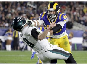 FILE - In this Dec. 16, 2018, file photo, Los Angeles Rams defensive end Aaron Donald hits Philadelphia Eagles quarterback Nick Foles after Foles threw the ball away during the first half in an NFL football game in Los Angeles. The Rams know they've got to pressure Tom Brady early and often to have a chance in the Super Bowl, and they've been assembling the tools for this job all year long. They signed Ndamukong Suh to a big free-agent deal, wrote a record-breaking contract for Aaron Donald and acquired edge rusher Dante Fowler from Jacksonville down the stretch.