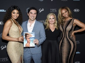 FILE - In this Feb. 14, 2018 file photo, model Danielle Herrington,  from left, Sports Illustrated editor-in-chief Chris Stone, S.I. Swimsuit editor MJ Day, and model Tyra Banks attend the 2018 Sports Illustrated Swimsuit Issue launch party in New York. The upcoming Sports Illustrated Swimsuit Issue is moving its publication date, pushing it from the chill of February to warmer May, closer to bikini-weather. Editor of the issue MJ Day says the shift makes more sense for greater impact. She says; "It's always hard to think about buying a swimsuit when its 18 degrees out."