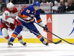 Carolina Hurricanes' Calvin de Haan (44) fights for control of the puck with New York Islanders' Michael Dal Colle (28) during the first period of an NHL hockey game Tuesday, Jan. 8, 2019, in New York.