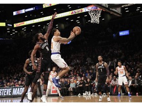 New York Knicks' Trey Burke (23) drives past Brooklyn Nets' DeMarre Carroll (9) during the first half of an NBA basketball game Friday, Jan. 25, 2019, in New York.