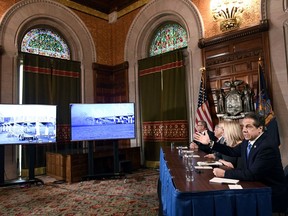 New York Gov. Andrew Cuomo watches from the Red Room in the state Capitol as the east anchor span of the old Tappan Zee Bridge is imploded by contractors Tuesday, Jan. 15, 2019, in Albany, N.Y.