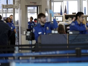FILE- In this Jan. 5, 2019, file photo Transportation Security Administration officers work at a checkpoint at O'Hare airport in Chicago. The percentage of TSA airport screeners missing work has hit 10 percent as the partial government shutdown stretches into its fifth week. The Transportation Security Administration said Monday, Jan. 21, that Sunday's absence rate compared to 3.1 percent on the comparable Sunday a year ago.