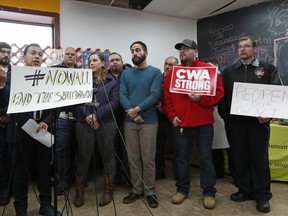 Mexicn-born lawyer and immigrants' rights activist Cesar Vargas, second from left, speaks to the media during a press conference and rally supporting two furloughed federal workers, National Park Service rangers Kathryn Gilson, fourth from left, and Sean Ghazala, third from right (in blue sweater), Thursday, Jan. 10, 2019, at La Colmena Center in the Staten Island borough of New York. Some union workers joined in support of the furloughed workers as the government shutdown entered it's 20th day. Gilson works at Jamaica Bay Wildlife Refuge, part of Gateway National Recreation Area and Ghazala works at the African Burial Ground in Lower Manhattan.