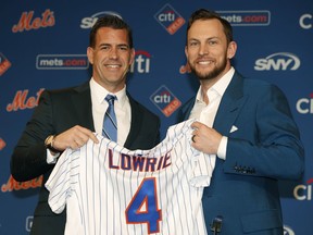 New York Mets General Manager Brodie Van Wagenen, left, poses for a photograph with All-Star infielder Jed Lowrie after Lowrie signed with the Mets, Wednesday, Jan. 16, 2019, in New York.