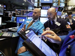 Specialist Meric Greenbaum, left, and trader Fred DeMarco, center, work on the floor of the New York Stock Exchange, Tuesday, Jan. 8, 2019. Stocks are opening broadly higher on Wall Street, building on two days of solid gains.