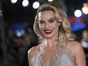 FILE - In this Monday, Dec. 10, 2018, file photo, actress Margot Robbie poses for photographers upon her arrival at the premiere of the film "Mary Queen of Scots," in London. Robbie will bring the Barbie doll to life in a live-action film. Mattel and Warner Bros. Pictures announced Tuesday, Jan. 8, 2019, that Robbie will star as the iconic doll in the franchise's first-ever live-action film. The 28-year-old "Suicide Squad" actress will also co-produce the film under her LuckyChap Entertainment banner.