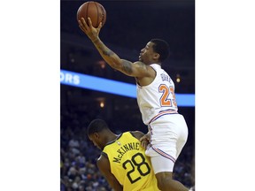 New York Knicks' Trey Burke, right, lays up a shot over Golden State Warriors' Alfonzo McKinnie (28) during the first half of an NBA basketball game Tuesday, Jan. 8, 2019, in Oakland, Calif.