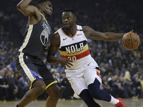 New Orleans Pelicans' Julius Randle, right, drives the ball against Golden State Warriors' Kevon Looney during the first half of an NBA basketball game Wednesday, Jan. 16, 2019, in Oakland, Calif.