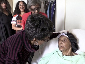 FILE - In this Sept. 22, 2018 file photo, Lessie Brown, right, is visited by her daughters, Verline Wilson, foreground, and Vivian Hatcher, third from left, and other family and friends at her home in Cleveland Heights, Ohio. A grandson said Brown, the 114-year-old Ohio woman who was believed to be the oldest person in the United States, died Tuesday. Jan. 8, 2019.