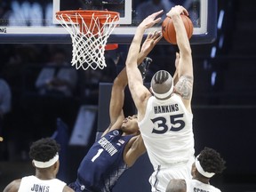 Xavier's Zach Hankins (35) blocks a shot by Georgetown's Jamorko Pickett (1) during the first half of an NCAA college basketball game, Wednesday, Jan. 9, 2019, in Cincinnati.