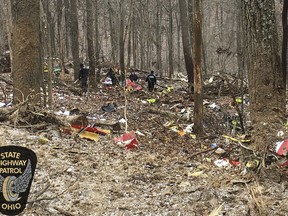 In this photo provided by the Ohio State Highway Patrol, authorities survey the scene of wreckage where a medical helicopter crashed in a remote wooded area in Brown Township, Ohio, on its way to pick up a patient, Tuesday, Jan. 29, 2019. There had been no reports of anyone else injured in the crash. No names were released immediately. A few crew members were all killed in the crash, authorities said.