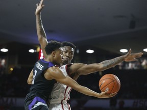 Kansas State guard Kamau Stokes takes an underhand shot in front of Oklahoma forward Kristian Doolittle during the first half of an NCAA college basketball game in Norman, Okla., Wednesday, Jan. 16, 2019.