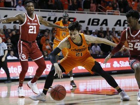 Oklahoma State guard Lindy Waters III, center, and Oklahoma forward Kristian Doolittle, left, and guard Jamal Bieniemy (24) watch a loose ball during the first half of an NCAA college basketball game in Stillwater, Okla., Wednesday, Jan. 23, 2019.