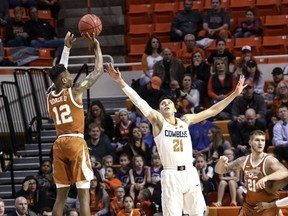 Texas' Kerwin Roach II attempts a 3-point shot over Oklahoma State's Lindy Waters during the first half of an NCAA college basketball game Tuesday, Jan. 8, 2019, in Stillwater, Okla.