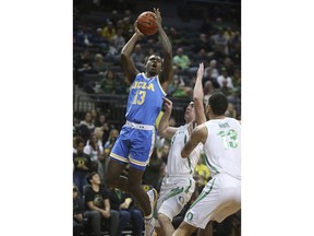 UCLA's Kris Wilkes, left, shoots over Oregon's Payton Pritchard, center, and Paul White, right, during the the first half of an NCAA college basketball game Thursday, Jan 10, 2019, in Eugene, Ore.