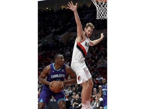 Charlotte Hornets center Bismack Biyombo, left, gets Portland Trail Blazers forward Jake Layman, right, into the air during the first half of an NBA basketball game in Portland, Ore., Friday, Jan. 11, 2019.