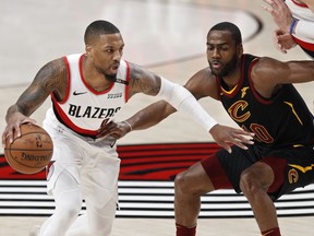 Portland Trail Blazers guard Damian Lillard, left, drives against Cleveland Cavaliers guard Alec Burks during the first half of an NBA basketball game in Portland, Ore., Wednesday, Jan. 16, 2019.