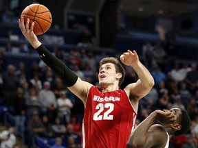 Wisconsin's Ethan Happ (22) goes to the basket over Penn State's Mike Watkins (24) during first half action of an NCAA college basketball game in State College, Pa. Sunday, Jan. 6, 2019.