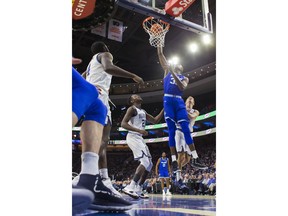 Seton Hall's Romaro Gill, center, dunks as Villanova's Dhamir Cosby-Roundtree, left, and Collin Gillespie, right, defend during the first half of an NCAA college basketball game, Sunday, Jan. 27, 2019, in Philadelphia.