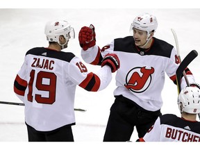 New Jersey Devils' Travis Zajac (19) celebrates his goal with Miles Wood (44) during the first period of an NHL hockey game against the Pittsburgh Penguins in Pittsburgh, Monday, Jan. 28, 2019.