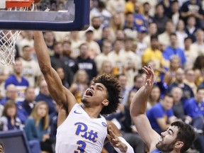 Pittsburgh's Malik Ellison (3) shoots after getting past North Carolina's Luke Maye, right, and Leaky Black (1) during the first half of an NCAA college basketball game, Saturday, Jan. 5, 2019, in Pittsburgh.