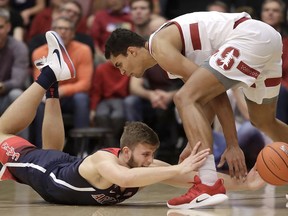 Arizona forward Ryan Luther, left, reaches for the ball under Stanford forward Oscar da Silva during the first half of an NCAA college basketball game in Stanford, Calif., Wednesday, Jan. 9, 2019.
