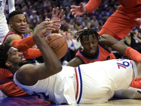 Philadelphia 76ers' Joel Embiid (21) grabs a loose ball next to Oklahoma City Thunder's Russell Westbrook, back left, and Jerami Grant during the second half of an NBA basketball game Saturday, Jan. 19, 2019, in Philadelphia. The Thunder beat the 76ers 117-115.