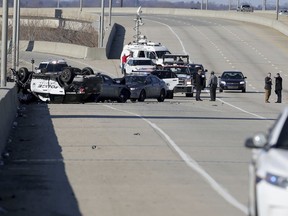 Police work at the scene along Interstate-95 North near the Philadelphia International Airport following a crash during a multi-state police chase Wednesday, Jan. 9, 2019, in Philadelphia. A Wilmington, Del., police vehicle, at left, flipped in the chase. Police launched a manhunt in South Philadelphia for a murder suspect who led police on a chase along Interstate 95, triggering a crash that left three officers injured, and then fled on foot after crashing into a SEPTA bus at Broad and Oregon Streets.