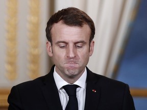 FILE - In this Monday, Dec. 17, 2018 file photo, French President Emmanuel Macron pauses before answering as he attends a media conference with Burkina Faso's President Roch Marc Christian Kabore at the Elysee Palace in Paris, France.  Macron is facing a mountain of challenges in 2019, starting with yellow vest protesters who are back on the streets to show their anger against high taxes and Macron's pro-business policies that they see as favouring the wealthy rather than the working class.