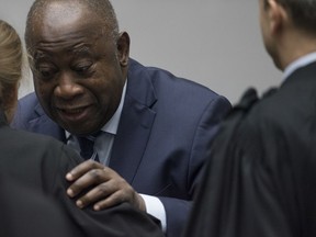 Former Ivory Coast President Laurent Gbagbo greets his legal team as he enters the courtroom of the International Criminal Court in The Hague, Netherlands, Tuesday, Jan. 15, 2019, where judges acquitted Gbagbo and ex-government minister Charles Ble Goude for lack of evidence.