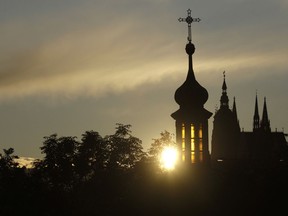 In this file picture taken on Oct. 13, 2009, the sun sets behind the St. Vitus cathedral in Prague, Czech Republic. On Wednesday Jan. 23, 2019, the lower house of Czech Parliament has approved a proposal drafted by the Communist Party to tax the compensation that the country's churches receive for property seized by the former Communist regime.