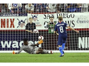United States midfielder Djordje Mihailovic (8) scores a goal against Panama goalkeeper Eddie Roberts, left, during the first half of a men's international friendly soccer match Sunday, Jan. 27, 2019, in Phoenix.