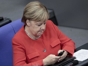 In this Sept.12, 2018 photo German Chancellor Angela Merkel (CDU) is looking at her mobile phone during the general debate in the German Bundestag.