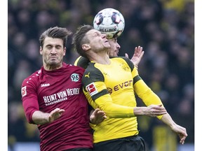 Hannover's Hendrik Weydandt, left, and Dortmund's Lukasz Piszczek fight for the ball during a Bundesliga soccer match between Hannover 96 and Borussia Dortmund in Hannover, Germany, Saturday, Jan. 26, 2019.