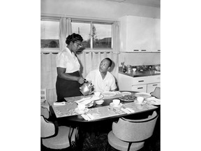 In this Aug. 19, 1957 file photo, Bill Myers is served coffee by his wife, Daisy, in their new home in Levittown, Pa. Samuel Snipes, a lawyer who represented the Myers, the first black family to move into the all-white development of Levittown in 1957, setting off racial conflict, has died. Snipes was 99.  His family says Snipes passed away Dec. 31, 2018 at his family farm in Morrisville, Pa.