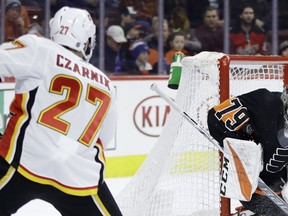 Philadelphia Flyers' Carter Hart, right, blocks a shot by Calgary Flames' Austin Czarnik during the first period of an NHL hockey game, Saturday, Jan. 5, 2019, in Philadelphia.