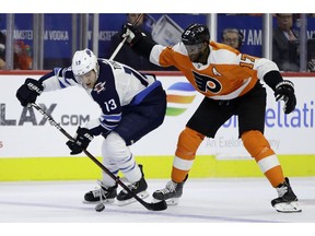 Winnipeg Jets' Brandon Tanev, left, and Philadelphia Flyers' Wayne Simmonds chase after the puck during the first period of an NHL hockey game, Monday, Jan. 28, 2019, in Philadelphia.