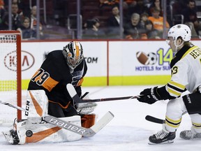 Philadelphia Flyers' Carter Hart, left, blocks a shot by Boston Bruins' Danton Heinen during the first period of an NHL hockey game, Wednesday, Jan. 16, 2019, in Philadelphia.