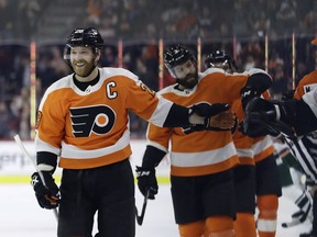 Philadelphia Flyers' Claude Giroux, left, celebrates with teammates after scoring a goal during the first period of an NHL hockey game against the Minnesota Wild, Monday, Jan. 14, 2019, in Philadelphia.