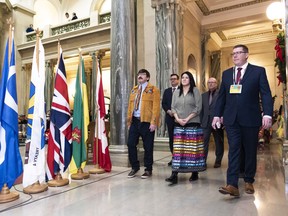Sixties Scoop Indigenous Society of Saskatchewan board members Robert Doucette, left, and Melissa Parkyn, front left and centre, Saskatchewan Party MLAs Paul Merriman and Warren Kaeding, rear left and right, and Premier Scott Moe enter the rotunda during the grand entry of the Apology to Sixties Scoop Survivors at the Legislative Building in Regina on Monday, January 7, 2019.