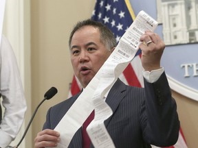 Assemblyman Phil Ting, D-San Francisco, displays a long paper receipt as he discusses his bill to require businesses to offer electronic receipts, Tuesday, Jan. 8, 2019, in Sacramento, Calif. Under the legislation customers could receive a paper receipt on request.