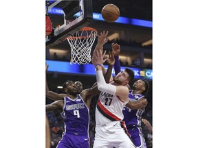 Portland Trail Blazers center Jusuf Nurkic, center, goes up for the rebound between Sacramento Kings' Iman Shumpert, left, and Buddy Hield during the first quarter of an NBA basketball game Monday, Jan. 14, 2019, in Sacramento, Calif.