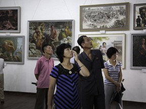 FILE - In this July 26, 2015, file photo, North Koreans look at paintings on display in Pyongyang, North Korea. South Korea says on Wednesday, Jan. 16, 2019, it has stopped businessmen from bringing in North Korean paintings in a potential violation of UN sanctions.