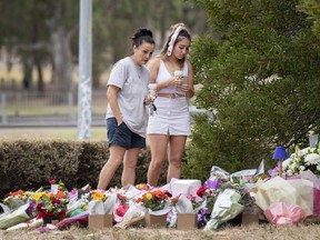 Two women stand at a floral tribute, Friday, Jan. 18, 2019, at the scene where the body of Israeli student Aiia Maasarwe was found earlier in the week in Melbourne, Australia. Maasarwe, a 21-year-old student who had been studying at La Trobe University in Melbourne, was slain at 12:10 a.m. on Wednesday shortly after she got off a tram in the suburb of Bundoora, according to police.