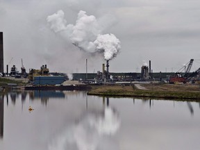 The Syncrude oil sands extraction facility is reflected in a tailings pond near the city of Fort McMurray, Alta., on June 1, 2014.