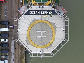 In this image taken from drone video people stand on the helipad of the Ocean Zephyr in the docks in Bremerhaven, Germany, Wednesday Jan. 23, 2019. Final preparations were being made Thursday for the start of an unprecedented, years-long mission to explore the Indian Ocean, during which scientists hope to document changes taking place beneath the waves that could affect billions of people in the surrounding region over the coming decades. The Britain-based Nekton Mission will use submarines to go 300 meters below the surface and sonar equipment to survey depths of up to 2,000 meters once the Ocean Zephyr reaches the Seychelles.